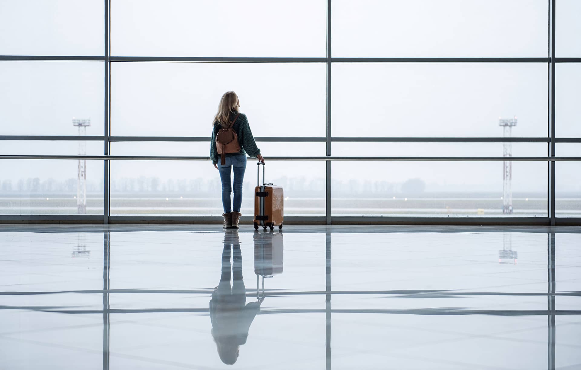 Frau alleine am Gate im Flughafen