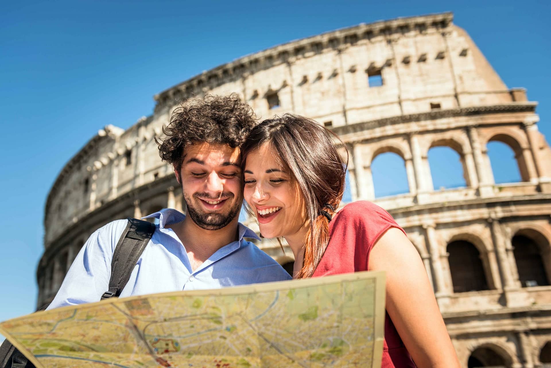 Tourists in front of the Colosseom in Rome reading a city map