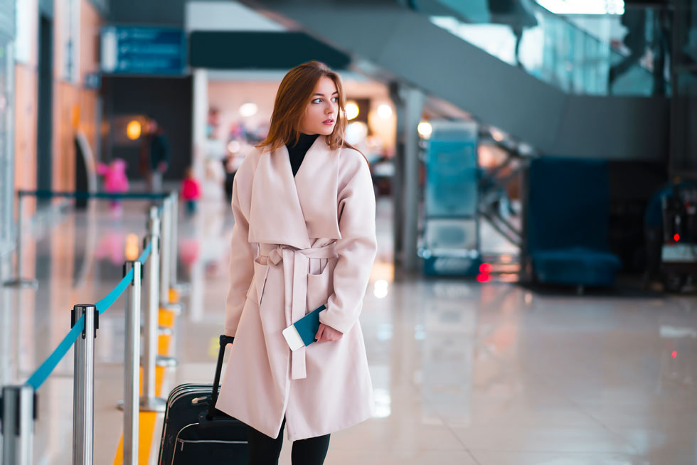 Frau mit Mantel und Koffer